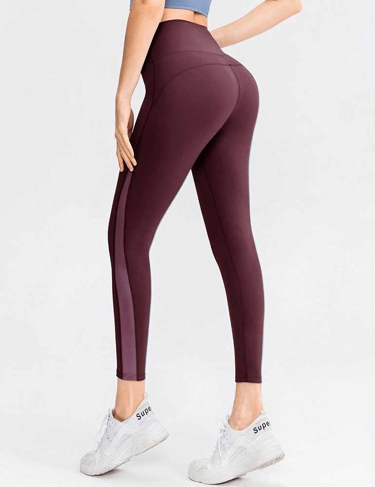 Woman wearing maroon sporty seamless leggings with high waist, showing back view, perfect for yoga, made of nylon and spandex.
